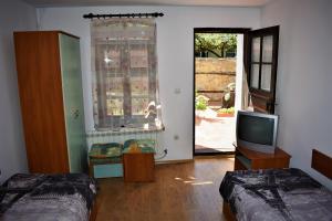 a living room with two beds and a television at Hotel Bilyana in Lovech