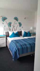 Un dormitorio con una cama azul y blanca con flores azules en la pared en em Dorfkrug, en Euskirchen