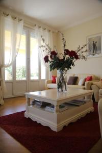 a living room with a vase of flowers on a coffee table at Plage du Midi in Cannes