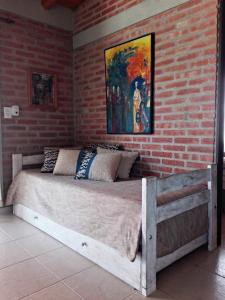 a bed in a room with a brick wall at Alma Serrana Apart Cabañas - Solo Adultos in Nono +38 photos