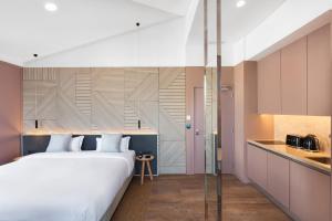 a bedroom with a large bed and a kitchen at OnJ S. Lazaro Lisboa in Lisbon