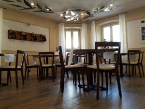 comedor con mesa, sillas y ventanas en Ai Vellutai, en Ala