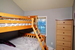 a bedroom with two bunk beds and a dresser at Chalets Alpins - 01 Chemin Alpin in Stoneham