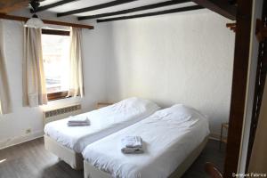 een slaapkamer met 2 bedden en handdoeken bij L'Auberge Saint Remacle in Stavelot