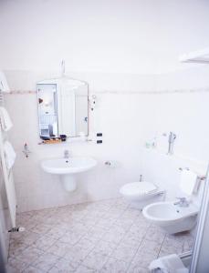bagno con 2 lavandini, servizi igienici e specchio di Hotel Sebino a Sarnico