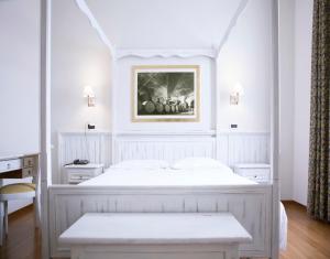 Un dormitorio con una cama blanca con una foto en la pared en Hotel Sebino en Sarnico