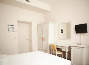 ein weißes Schlafzimmer mit Schreibtisch und Bett in der Unterkunft Hotel Sebino in Sarnico