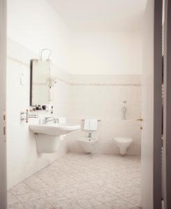 a white bathroom with a sink and a toilet at Hotel Sebino in Sarnico