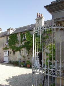 ein altes Haus mit einem Tor davor in der Unterkunft Maison Normande in Asnelles