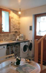 a kitchen with a washing machine and a table at La Poussiniere in Auvers-Saint-Georges