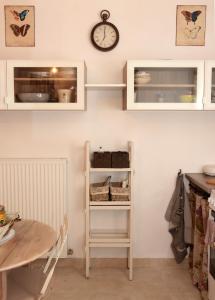 a kitchen with a table and a clock on the wall at La Poussiniere in Auvers-Saint-Georges