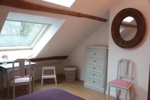 a bedroom with a window and a dresser and a mirror at La Poussiniere in Auvers-Saint-Georges
