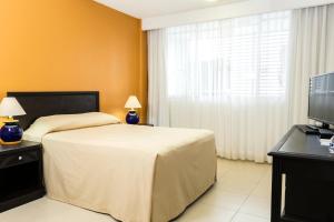 a hotel room with a bed and a television at Hotel Miraflores Villahermosa in Villahermosa