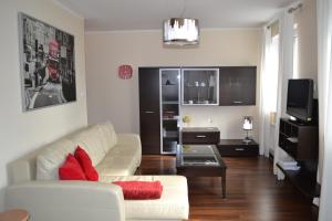 a living room with a white couch and a table at Apartament Bella Nova Centrum in Olsztyn