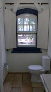 a bathroom with a toilet and a window at Casas dos Sonhos in Paraty