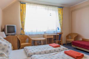ein Hotelzimmer mit 2 Betten und einem TV in der Unterkunft Rekreačný Dom Mengusovce in Mengusovce