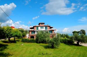 a large house on a grassy field with trees at Bed and Breakfast Ocarè in San Gemini