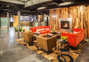a living room with orange furniture and a fireplace at Warehouse Hotel at The Nook in Manheim