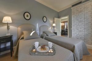 a bedroom with two beds with a tray of food on it at Lanfredini Firenze in Florence