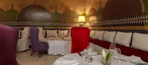 a dining room with two tables and chairs and a lamp at Soundouss Hotel in Rabat