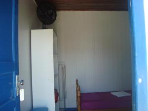 Habitación con cama y reloj en la pared en Dona Quinota, en Ilha do Mel