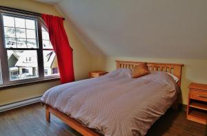 - une chambre avec un lit doté d'un rideau rouge et d'une fenêtre dans l'établissement Chalet 9014 Chemin des Alpages by Les Chalets Alpins, à Stoneham
