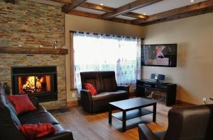un salon avec un canapé et une cheminée dans l'établissement Chalet 9014 Chemin des Alpages by Les Chalets Alpins, à Stoneham