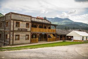 a large wooden building with a balcony and a tent at Ranč pod Ostrou Skalou in Stratená