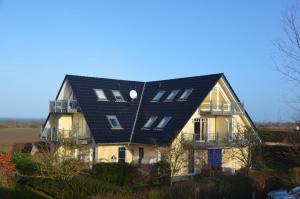 una casa con un techo negro encima en Ostseeblick, en Ostseebad Nienhagen