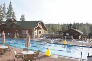 a swimming pool with tables and chairs and a building at Stockholm Luxury Retreat in Truckee