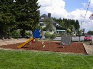 a playground with a slide in a yard at Hotel Aux Massotais in Petites Tailles