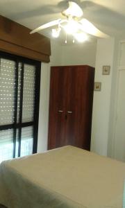 マラガにあるCasa Manuel y Maribel2024のベッドルーム1室(天井ファン、木製ドア付)