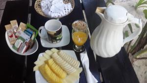 een tafel met een bord bananen en een kan sinaasappelsap bij Chancabañita Tulum in Tulum