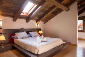 a bedroom with a large bed with wooden ceilings at Aiestaenea Apartamentos Rurales in Isaba