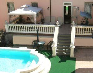 モンテカティーニ・テルメにあるHotel Innocentiの白い傘と階段のあるスイミングプール