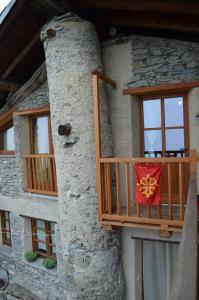 a balcony of a house with a flag on it at Rota d'Amont in Stroppo