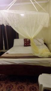 Una cama con dosel y almohadas. en Juddy Place en Nairobi