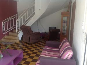 ein Wohnzimmer mit einem Sofa und einer Treppe in der Unterkunft Villa Les Violettes in Morne-à-lʼEau