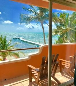 a balcony with chairs and a view of the ocean at Seaside Villas in Caye Caulker
