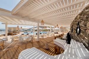 a patio with white chairs and tables on a deck at Osom Resort in Ornos