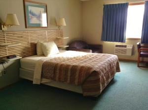 A bed or beds in a room at SunRise Inn Hotel