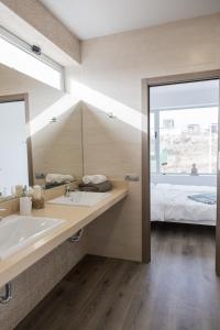a bathroom with a sink and a bed and a mirror at Diamond Buddha in Melenara