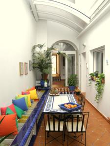 uma sala de estar com uma mesa e almofadas coloridas em B&B Casa Alfareria 59 em Sevilha
