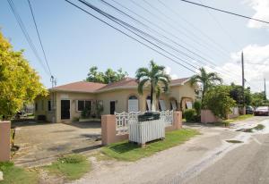 a house with a fence in front of a street at Cozy Nest in George Town