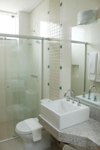 ein Bad mit einem Waschbecken, einem WC und einer Dusche in der Unterkunft Hotel Cadori in Paiçandu