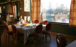 una sala da pranzo con tavolo, sedie e finestra di Agriturismo Il Boschetto a Ornago