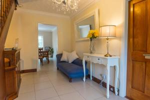 a living room with a blue chair and a table with a vase of flowers at Dorney's B&B in Gorey