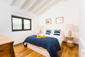a white bedroom with a bed with a blue blanket at Quinta do Gato, Douro Valley, Armamar in Armamar +21 photos