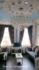 a living room with a chandelier hanging from a ceiling at Fewo Meissen in Meißen