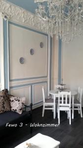 a dining room with a table and chairs and a chandelier at Fewo Meissen in Meißen +64 photos